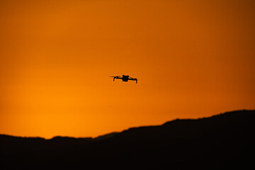 Drone silhouette soaring above Cretan mountains at sunset—where modern technology meets the timeless beauty of Mediterranean skies