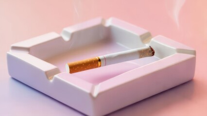 Cigarette resting in a white ashtray on a pink surface.