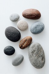 Fototapeta premium A Serene Arrangement of Smooth, Varied River Stones on a Clean White Background.