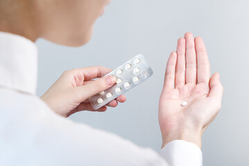 Close-up of woman taking pills in her open hand.