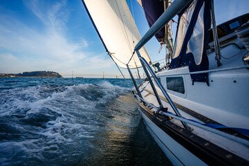Sailboat sailing on the water with a bridge in background