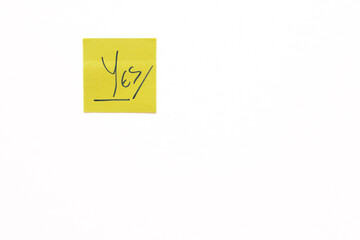 Yellow sticky note with handwritten yes text, showing agreement