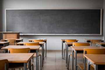 Empty vintage classroom with wooden desks and blackboard
