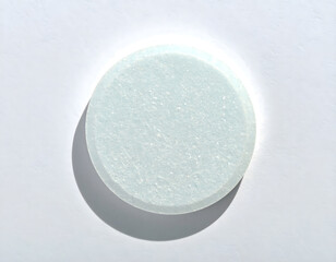 Transparent round object casting subtle shadow on white background