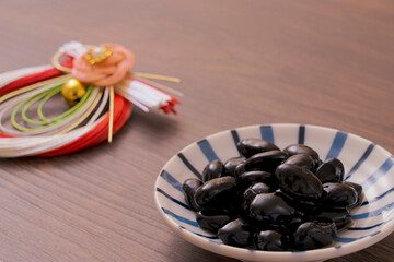 A traditional dish made for Japanese New Year's celebrations. Boiled black beans.正月などに作られる日本の伝統的な料理。黒豆の煮豆。