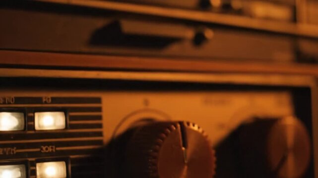 Cinematic CloseUp of Hand Turning the Effects Knob on a Vintage Amplifier in Warm Moody Light.
