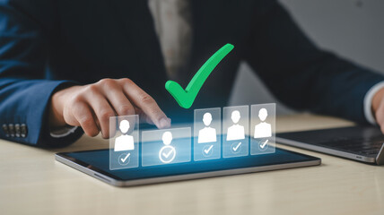 A businessman is using a tablet to select the best candidate for a job, with a green check mark indicating the selected candidate