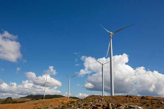 Turbinas de vento em parque de energia e&oacute;lica contra c&eacute;u azul com nuvens