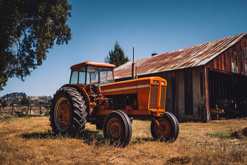 Fototapeta premium Vintage orange tractor parked beside rustic barn in countryside