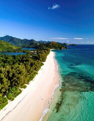 Aerial view of a pristine, secluded beach with white sand, turquoise water, lush greenery, and distant mountains under a vibrant blue sky