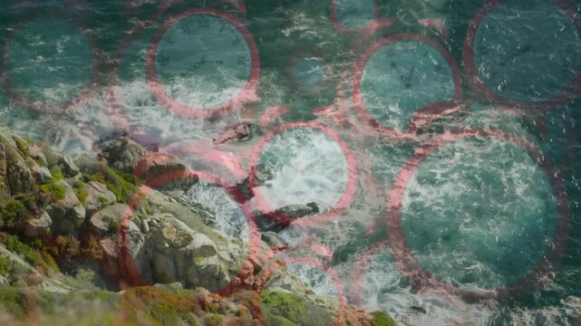 Red circular grid appearing, rocky shore, rolling ocean waves crashing, illustrating shore dynamics