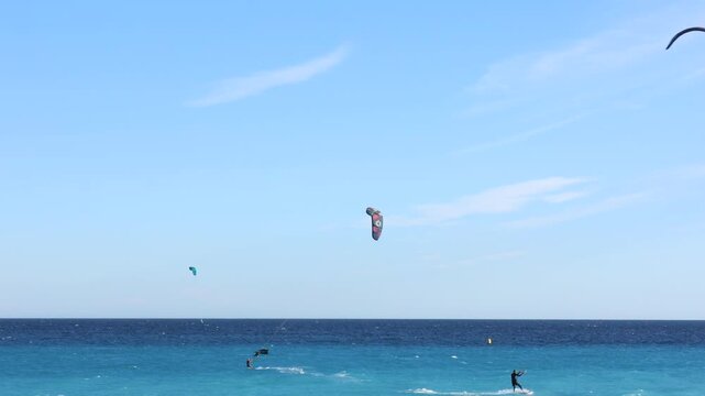 Beautiful view of wavy sea and people parasailing on sunny day