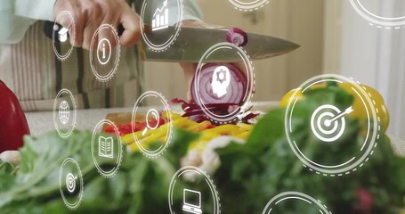 Home cook slicing red onion on board activating cooking assistant with icons guiding recipe - Powered by Adobe