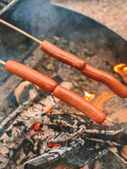 roasting hotdogs over fire
