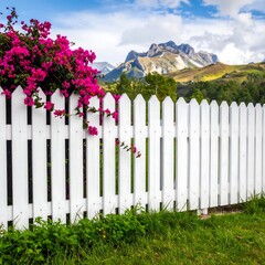 Picturesque white picket fence with vibrant pink flowers and mountains in the background