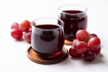 Red grape juice in glass and fresh grapes fruit on white background, Healthy drink
