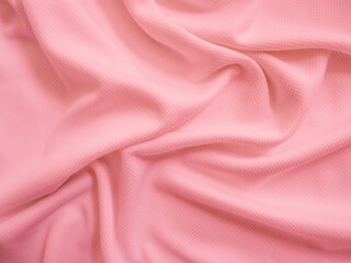 Pink crumpled  fabric background. Wavy cloth texture