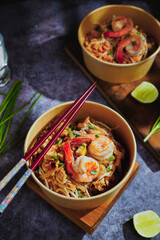 Pad Thai stir-fried with shrimp, eggs, peanuts and lime, served in paper.