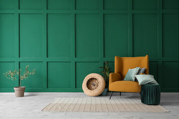 Interior of living room with brown armchair, houseplant, cushions and pouf