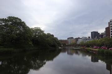 Overcast sky with thick gray clouds stretching across the horizon, creating a calm yet moody atmosphere above a distant landscape.