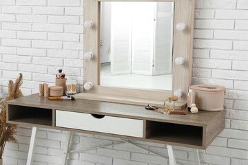 Dressing table with cosmetics and mirror in stylish makeup room