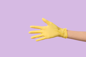 Female hand in medical glove on lilac background