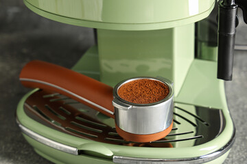 Portafilter with powder in modern coffee machine, closeup