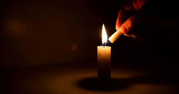 Illuminating Hope: A Close-Up of a Candle Being Lit in a Dark Room with Soft Light
