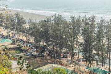A stunning view of the peaceful beach at Cox’s Bazar, Bangladesh, with trees lining the shore and the clear blue ocean.