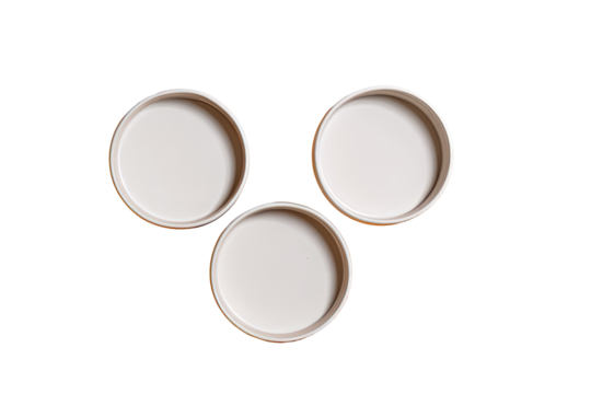 Three white circular lids arranged in a triangle formation against a transparent background