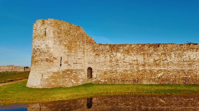 Medieval English Castle at Pevensey, East Sussex, England, UK, showing gatehouse arches, flint masonry and open grass