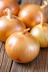 Fresh yellow onions resting on rustic wooden table