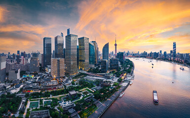 Financial district with modern skyscrapers illuminated by a golden sunset in Shanghai.