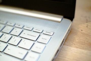Close-up of a silver laptop keyboard focusing on the delete keys, showing modern minimalist design and detail