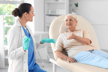 Obraz premium Senior woman with doctor talking about vaccination in clinic