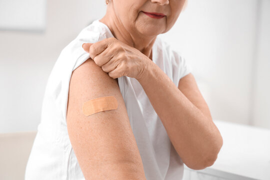 Senior woman with medical patch after vaccination in clinic, closeup