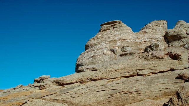 Mushroom shaped and anthropomorphic rock formations in a beautiful mountain range, displaying weathered stone columns, rounded caps, and curious silhouettes, under open sky across rugged terrain