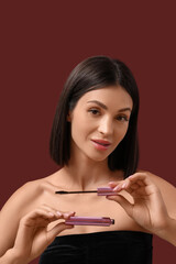 Naklejka premium Beautiful young woman with mascara on red background, closeup