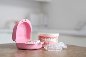 Box with occlusal splint and jaw model on table in dentist's office, closeup