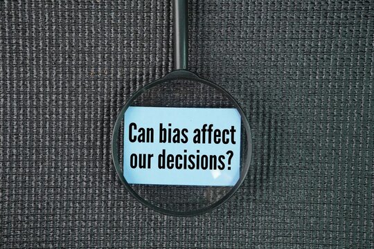 Magnifying glass and paper with the words question about BIAS Can bias affect our decisions?
