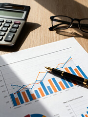 Financial chart with pen and calculator on desk
