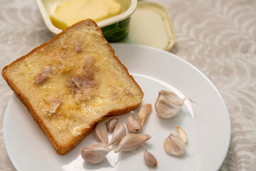 Garlic buttered bread slices before baking in an electric oven.