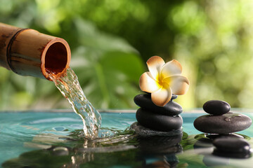 Lake with spa stones and beautiful plumeria in tropical bamboo garden