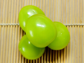 Close-up shot of fresh green grapes on a wooden surface, highlighting their vibrant color and texture