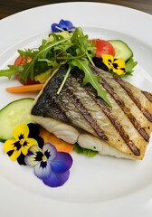 Grilled fish fillet with salad and edible flowers on a white plate presentation is amazing wow