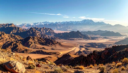 Vast Desert Landscape with Rocky Terrain Under Clear Blue Sky and Distant Snowy Mountain Range at Daytime Wide Angle View