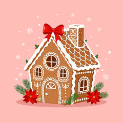 A charming festive gingerbread house decorated with icing and a red bow.