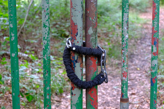A chain is wrapped around a metal fence post