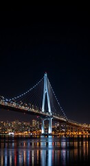 Stunning modern suspension bridge illuminated at night with vibrant city lights reflecting on calm water below
