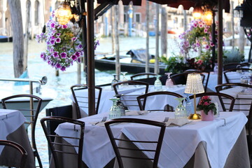 Dusk view of restaurant tables along Grand Canal in Venice, Italy